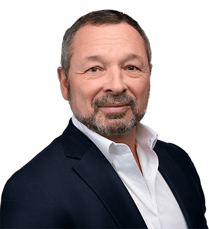 Alan Cameron, a middle-aged man with short hair and a beard, wearing a dark suit jacket over a white collared shirt, poses against a plain background.