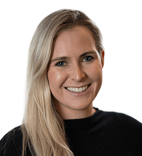 Caroline Shutt, a woman with long blonde hair and a black top, is smiling at the camera against a plain background.