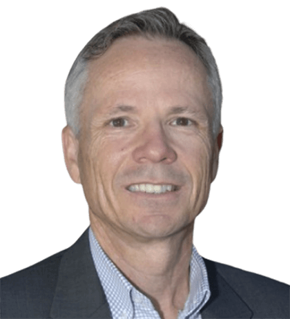 A middle-aged man with short gray hair, wearing a dark jacket and checkered shirt, smiling at the camera against a plain background.