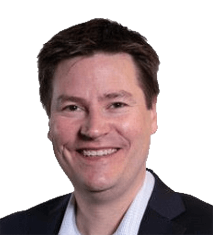 Jeff Palles, a man with short brown hair, is smiling, wearing a dark blazer over a light-colored shirt, against a plain black background.