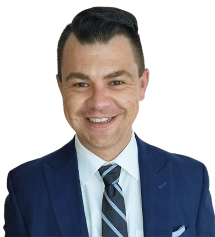 Ryan Carrier, wearing a blue suit, white shirt, and striped tie, is smiling at the camera.