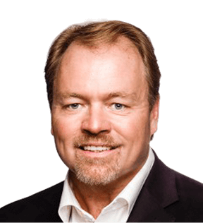 Steve Meehan, a middle-aged man with light skin, short light brown hair, and a trimmed beard, wears a white shirt and dark blazer while smiling at the camera.