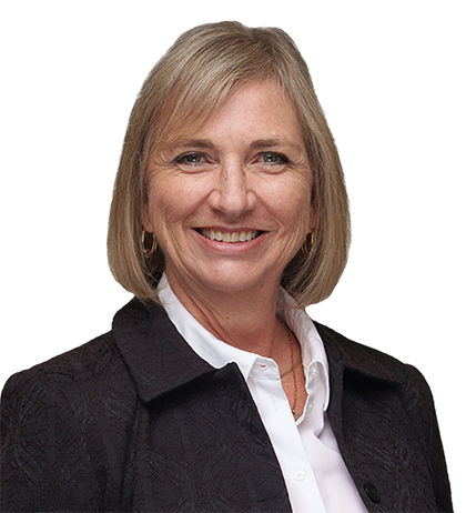 Brigitte Youngberg, a middle-aged woman with short blonde hair, wears a dark blazer over a white collared shirt and smiles at the camera against a neutral background.