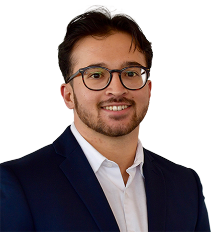 Carter Obando, a young man with short dark hair, glasses, and a beard, wears a navy suit jacket and white shirt, smiling at the camera against a transparent background.